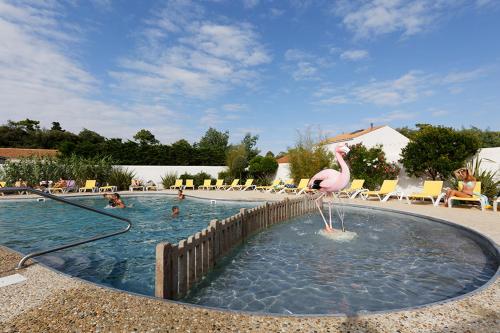 un flamingo est debout dans l'eau d'une piscine dans l'établissement Camping St Tro’Park **** - Maeva, à Saint-Trojan-les-Bains