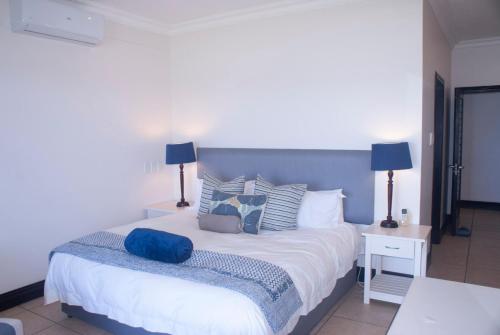 a bedroom with a large white bed with pillows at 2 Marichel Beachfront Condo in Ballito