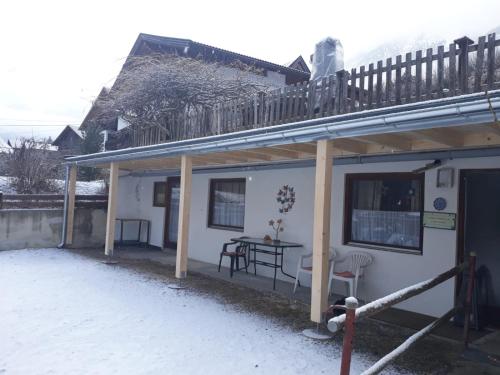 a small white house with a table and a balcony at apartment harmony in Sautens