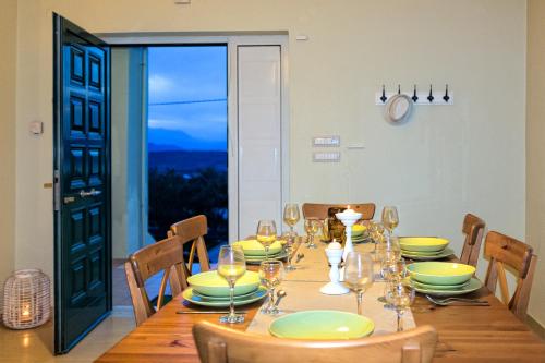 a dining room with a table with plates and wine glasses at Malena Organic Farm in Episkopí- Rethimno