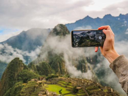 a person taking a picture of a mountain at ValPer boutique in Cusco