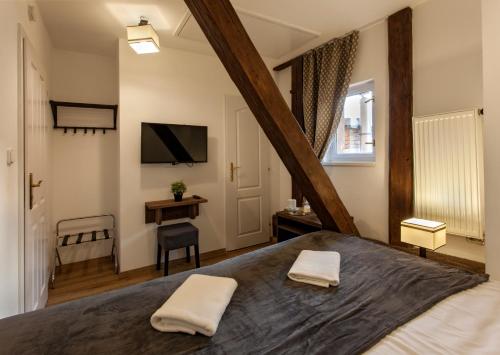 sypialnia z dużym łóżkiem i 2 białymi ręcznikami w obiekcie Residence Corto Old Town w Pradze
