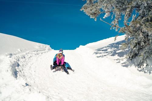 a person sitting in the snow on skis at aja Ruhpolding in Ruhpolding
