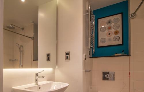 a white bathroom with a sink and a mirror at Holiday Inn - Leicester - Wigston by IHG in Leicester