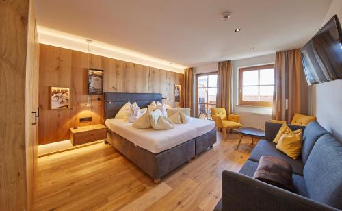 a hotel room with a bed and a couch at Bauernhof Hotel Oberschwarzach in Saalbach Hinterglemm