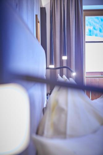 a room with a bed and a window at Bauernhof Hotel Oberschwarzach in Saalbach Hinterglemm