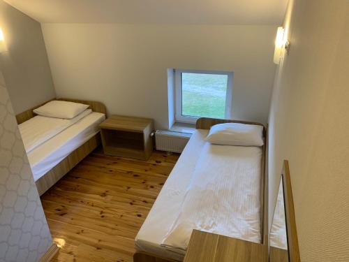 a small room with two beds and a window at Arka Agroturyska in Kosin