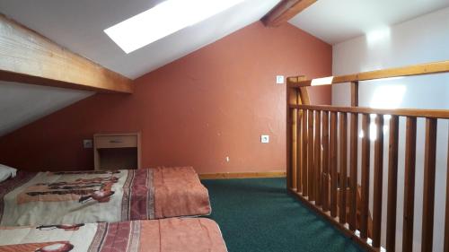 a attic room with a bed and a staircase at cellier 7 in Les Deux Alpes