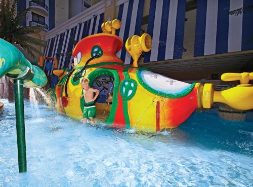 a young boy standing in front of a water slide at Compass Cove in Myrtle Beach
