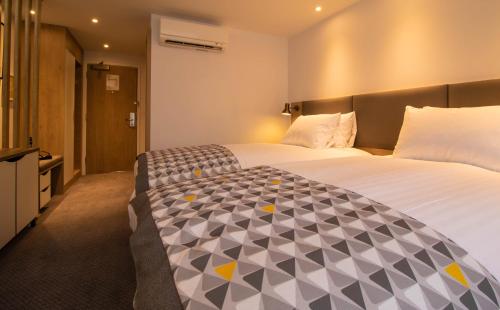 a hotel room with a large bed and a television at Holiday Inn - Leicester - Wigston by IHG in Leicester