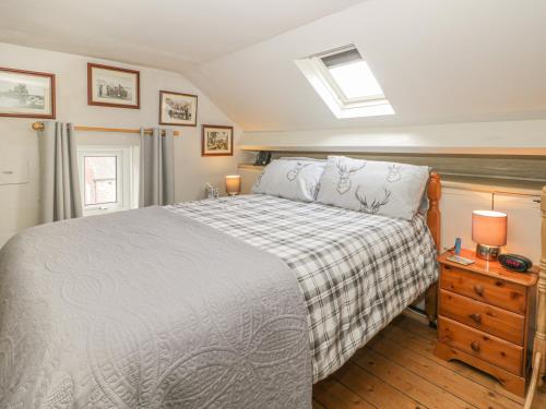 a bedroom with a bed and a night stand with two lamps at Chapel Cottage in Filey