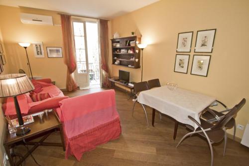 een woonkamer met een bank en een tafel en stoelen bij PROMENADE HOLIDAY - GRIMALDI CITY CENTER in Nice