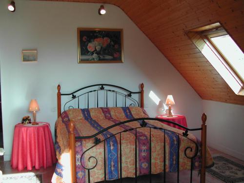 a bedroom with a bed and two tables with lamps at Le Domaine de Rugornou Vras in Brasparts