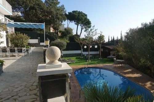 una piscina con una estatua junto a una casa en Feel at Lloret de mar, en Lloret de Mar