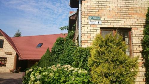 un edificio de ladrillo con un letrero en la calle en Cozy House Mētriņi en Ķekava