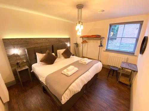 ein Schlafzimmer mit einem Bett mit zwei Handtüchern darauf in der Unterkunft Loft at The Coach House Apartments in Leeds