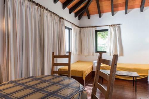 een slaapkamer met een bed en een tafel en stoelen bij Pedras Del Rei I in Tavira