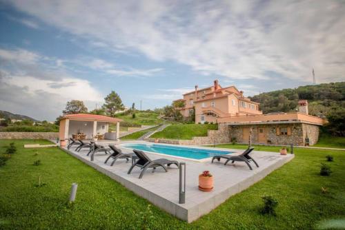 ein Haus mit Pool und Stühlen im Hof in der Unterkunft Apartments Dionis in Rab