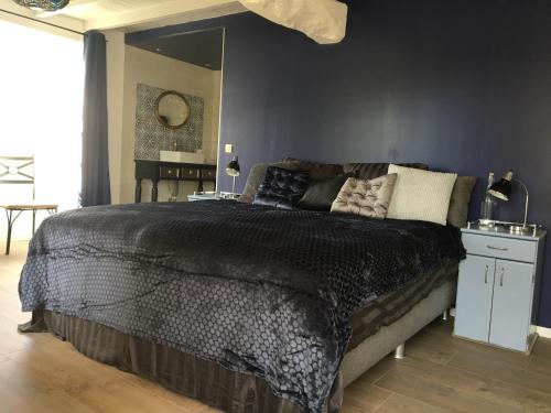 1 dormitorio con 1 cama grande y edredón negro en Domaine du Cammazet, en Lapenne