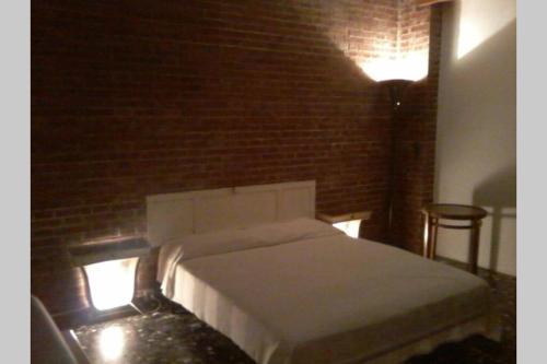 uma cama num quarto com uma parede de tijolos em Villa Biagi quadrilocale la Conchiglia em San Vincenzo