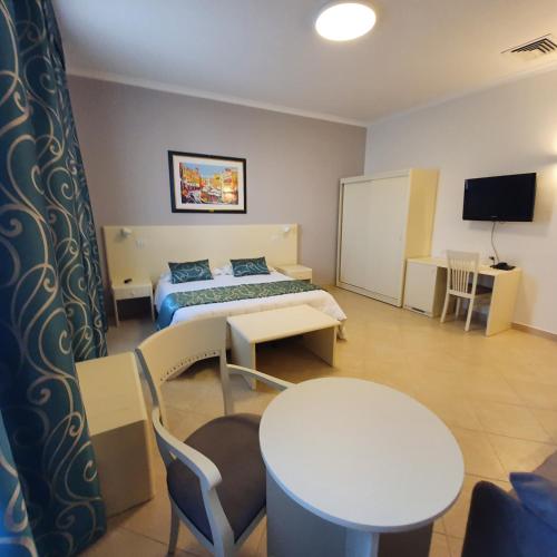 a hotel room with a bed and a table and chairs at Hotel Centrale Spa & Relax in Alcamo