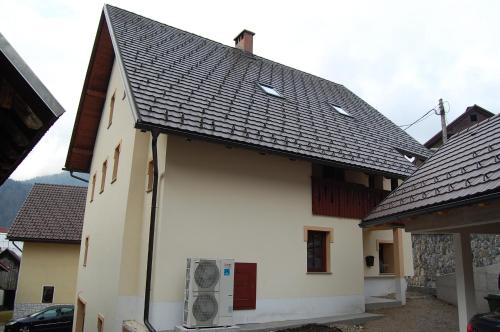 a white house with a black roof at Apartmaji Kramar Rateče in Kranjska Gora