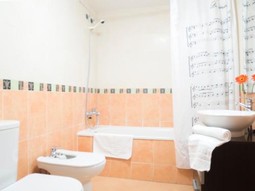 a bathroom with a toilet and a sink and a tub at Apartamentos Atenea Playa Romana in Alcossebre
