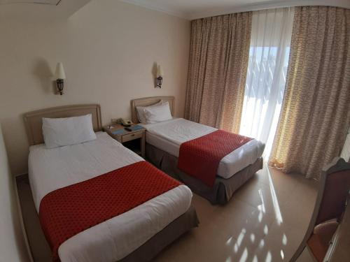 a hotel room with two beds and a window at Concorde El Salam Sharm El Sheikh Front Hotel in Sharm El Sheikh