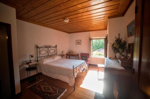 a bedroom with a bed and a wooden ceiling at Quinta da Picaria in Santo Tirso