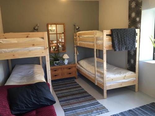 two bunk beds in a room with a mirror at Stenbrottets smedja in Falköping