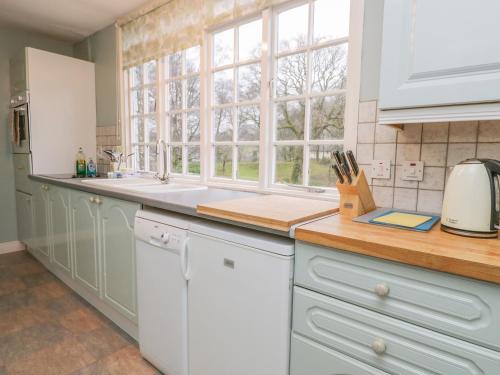 a kitchen with white cabinets and a sink and a window at Sethera in Ambleside