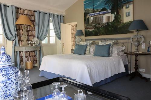 a bedroom with a bed with blue and white pillows at La Maison du Frene in Vence