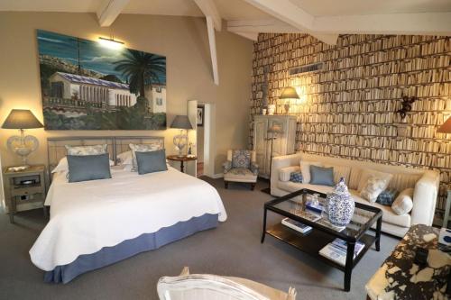 a bedroom with a large bed and a living room at La Maison du Frene in Vence