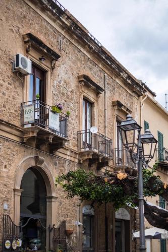 an old brick building with balconies and a street light at THE PALACE B&B and Apartments in Santo Stefano di Camastra