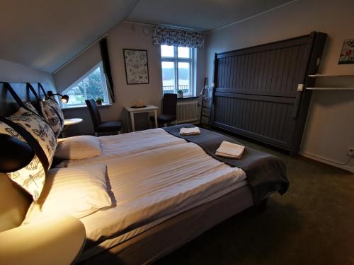 a hotel room with a large bed and a desk at Åhus B&B och Vandrarhem in Åhus