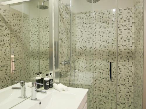 uma casa de banho com um chuveiro, um lavatório e um chuveiro em Serra do Pilar Porto Suites em Vila Nova de Gaia