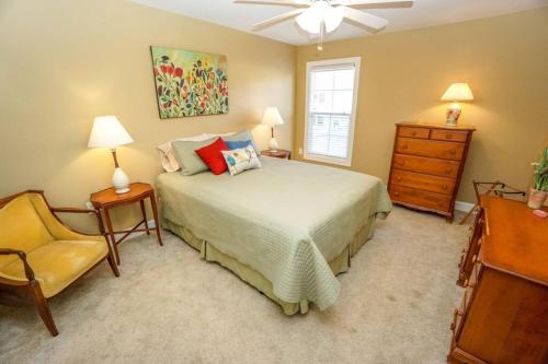 a bedroom with a bed and a chair and a dresser at Ideal Location! Perfect for Graduations and Lowcountry Getaways! in Port Royal