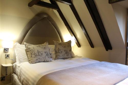 a bedroom with a bed with pillows on it at Lumley Castle Hotel in Chester-le-Street