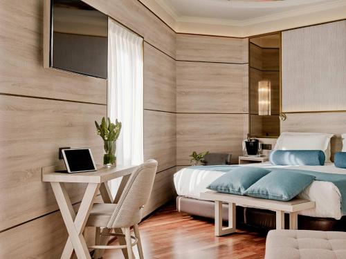 a bedroom with a bed and a desk with a laptop at Preciados in Madrid
