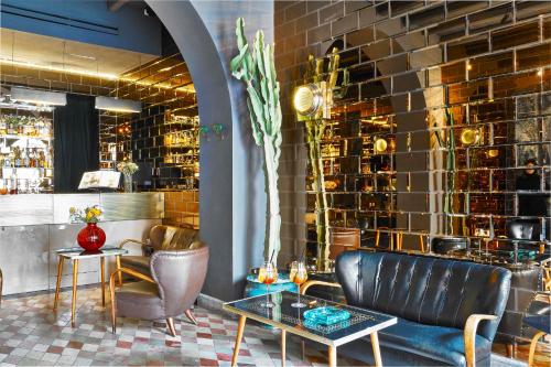 a lobby with a couch and chairs and a brick wall at G-Rough, Rome, a Member of Design Hotels in Rome