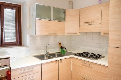 uma cozinha com armários de madeira e um lavatório em N216 - Numana, cielo-terra nei vicoli a 200mt dal mare em Numana