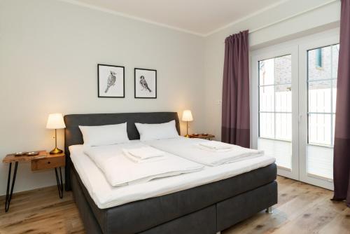 a bedroom with a large bed with white sheets at Fehmarn Mein Urlaub in Fehmarn