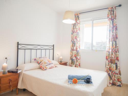 a bedroom with a white bed with a window and a bed sidx sidx at Apartamentos Doña Maria in Alcossebre
