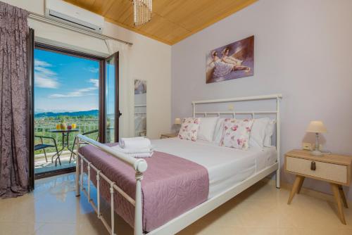 - une chambre avec un lit et un balcon dans l'établissement Filoxenia Stone House, à Kalpaki