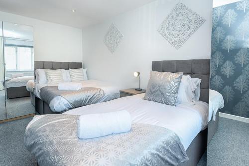 a bedroom with two beds and a window at Pleasant Stay in Swansea - TV in Every Bedroom! in Swansea