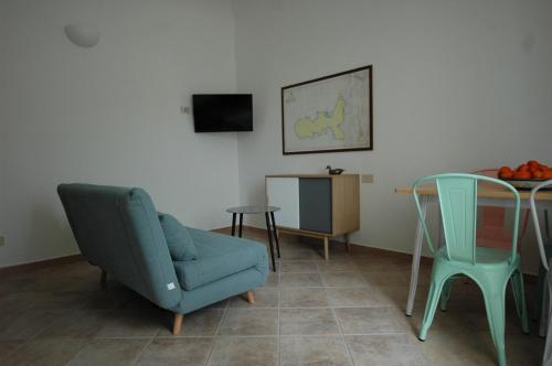 a living room with a blue chair and a table at Sansone Sul Mare Appartamenti in Portoferraio