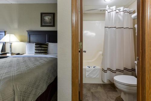 a hotel room with a bed and a toilet at Grand View Inn & Suites in Branson