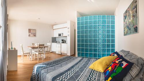 1 dormitorio con una pared de azulejos azules y una mesa en Ampuries Delta Apartment, en Empuriabrava