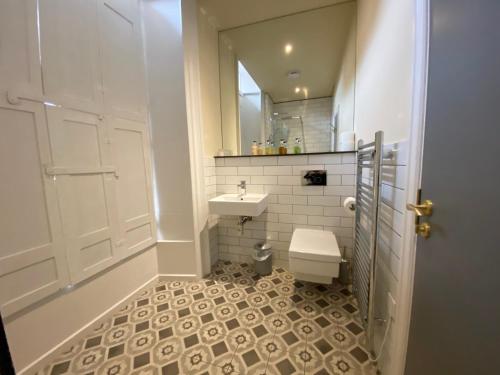 a bathroom with a toilet and a sink and a mirror at The Deakin at Claremont Serviced Apartments in Leeds