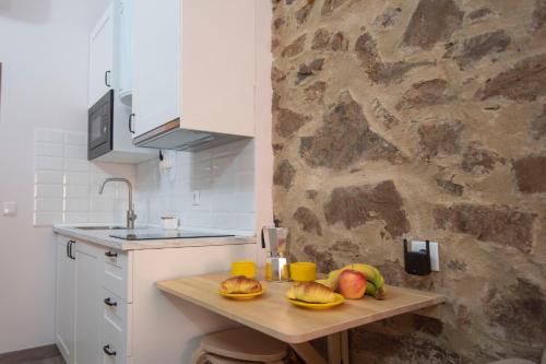 una cocina con una mesa de madera con fruta. en Apartamento nuevo Casco Antiguo AT Postigo 20, en Cáceres